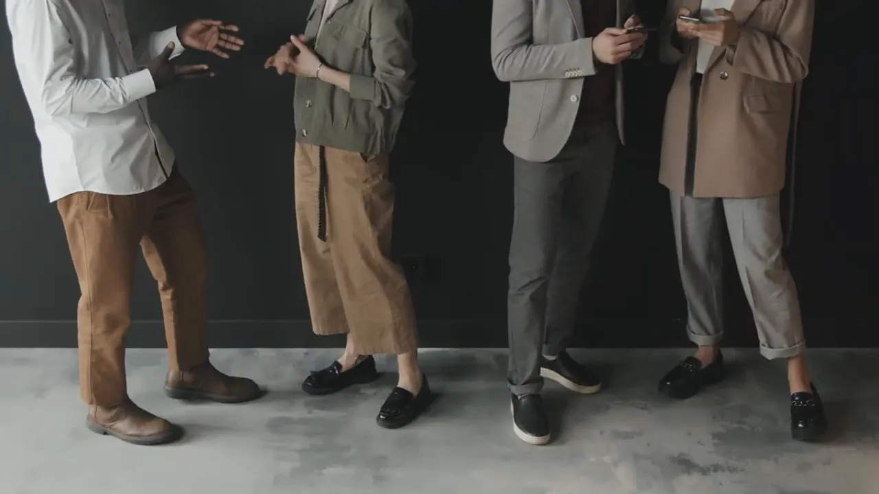 four people standing and talking, showing a small team in a casual business setting