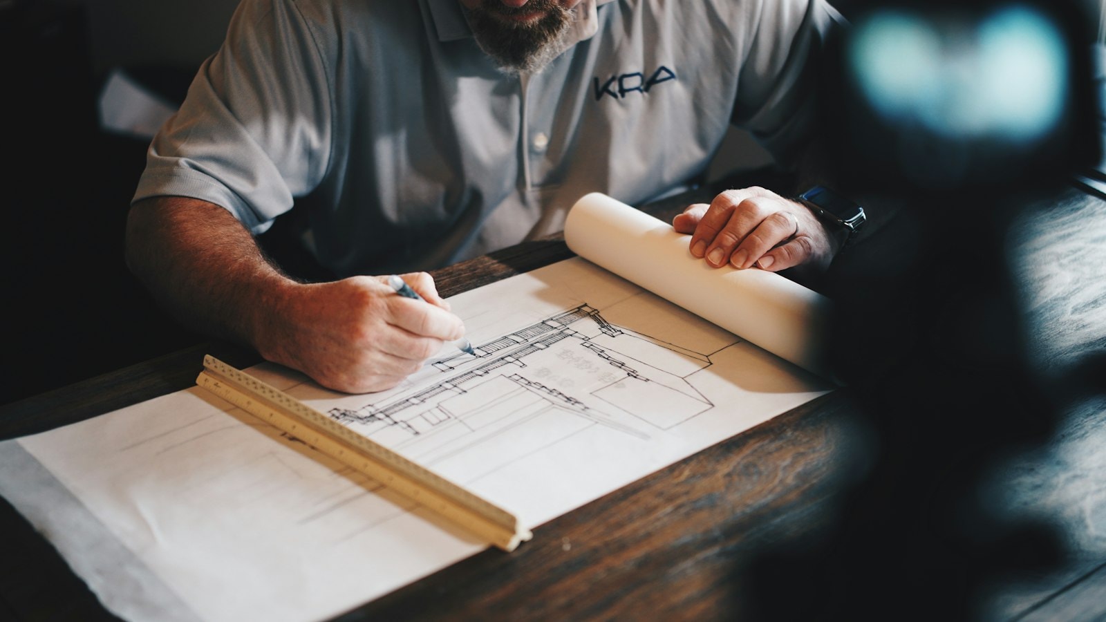 Architectural plans and drawing tools on a work surface