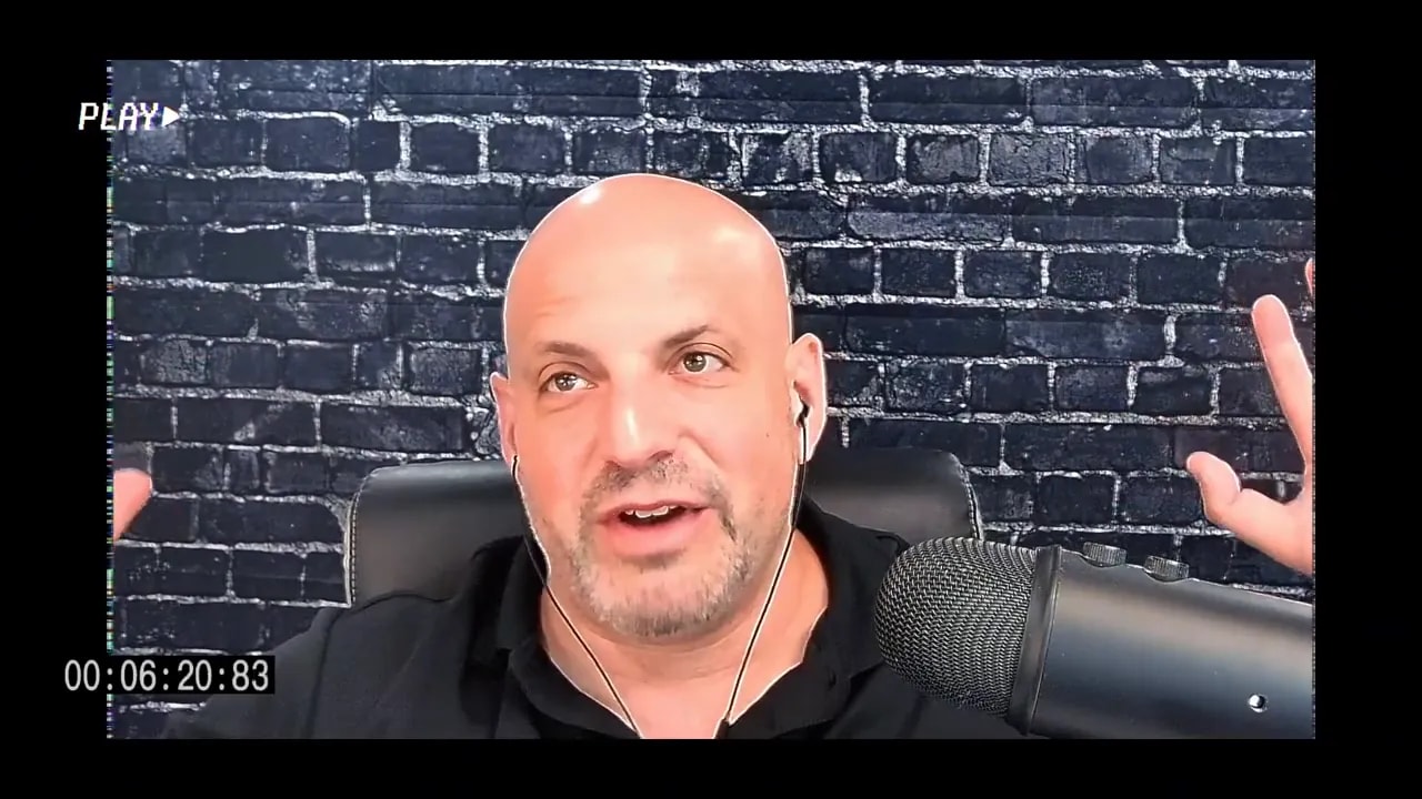 Business coach raising a hand while speaking into a microphone in an interview setting