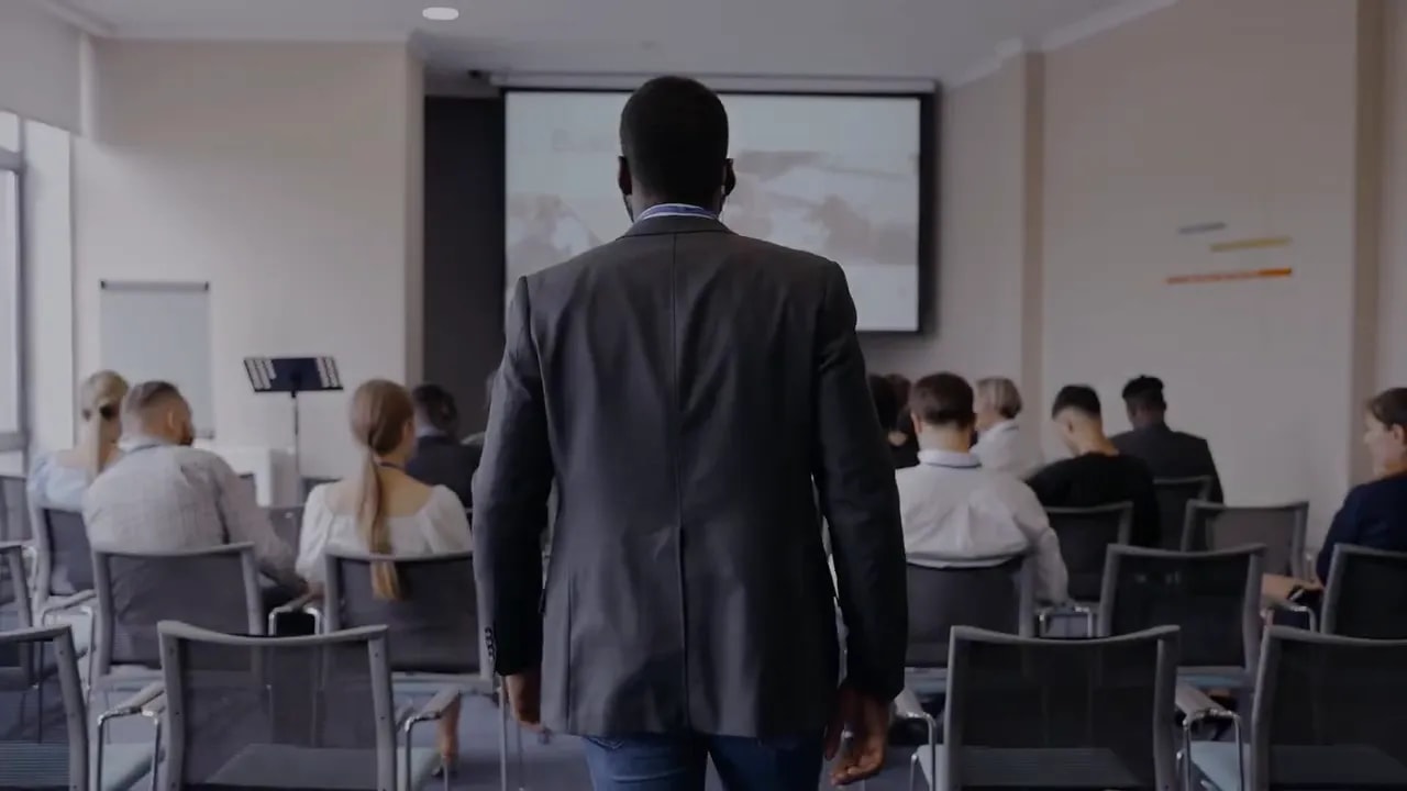 Businesspeople seated in a meeting room facing a presentation screen
