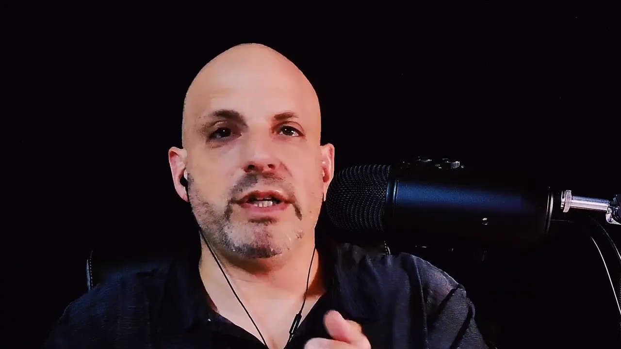 Person speaking with hands raised beside a microphone