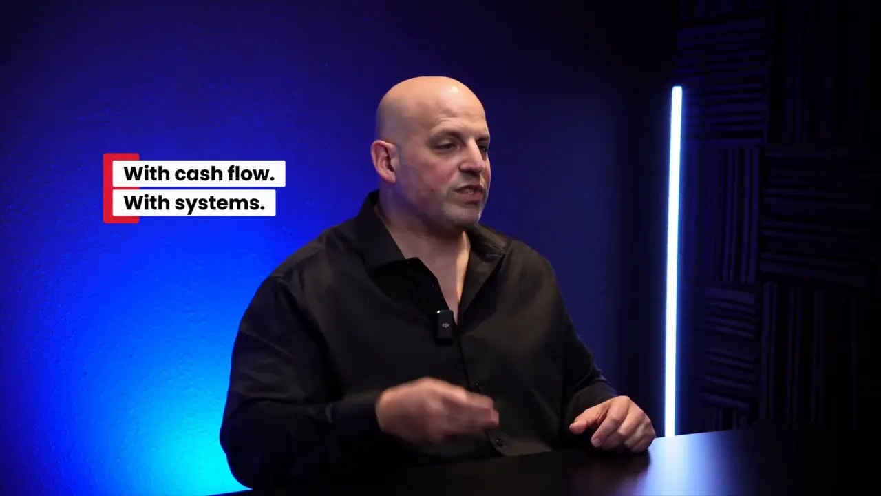 Business ownership coach discussing acquisition entrepreneurship with text overlay 'With cash flow. With systems.'