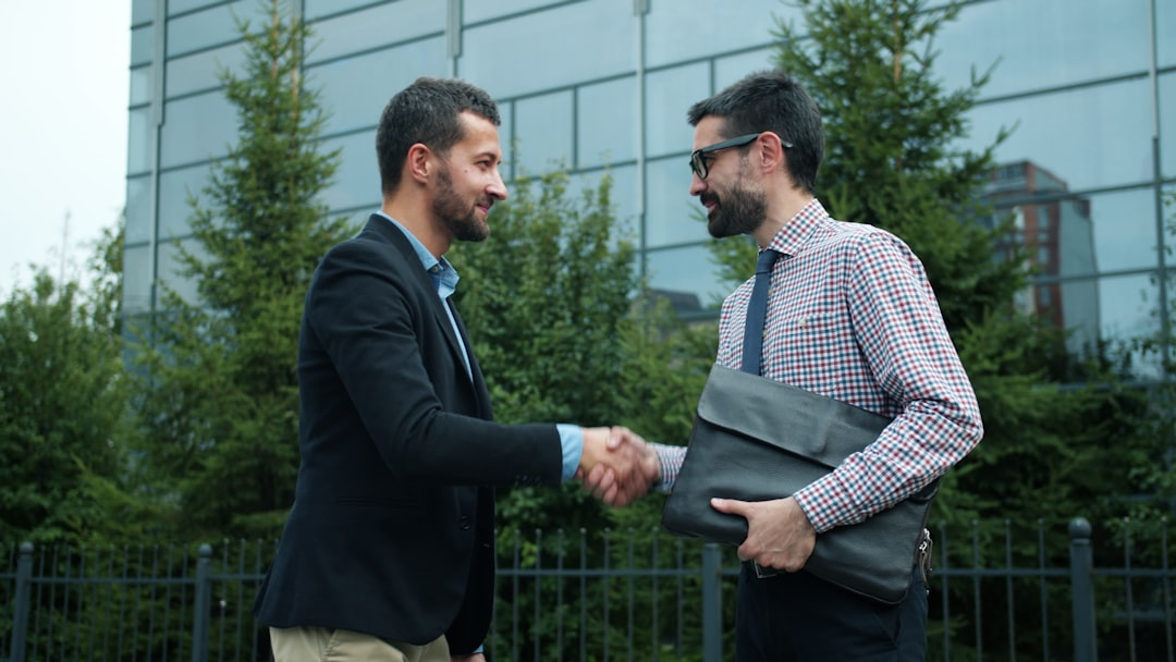 business coach meeting laptop documents handshake