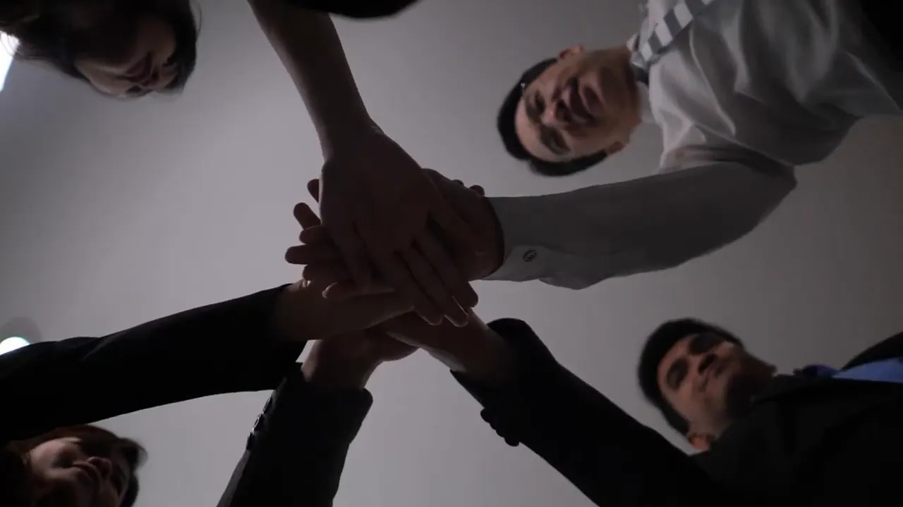 Team members stacking hands together in a circle