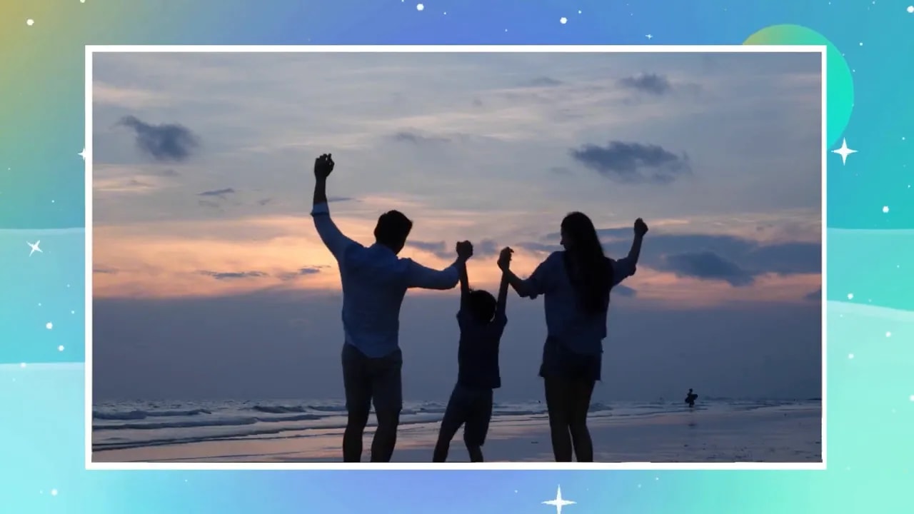Silhouette of parents and child holding hands on a beach at sunset
