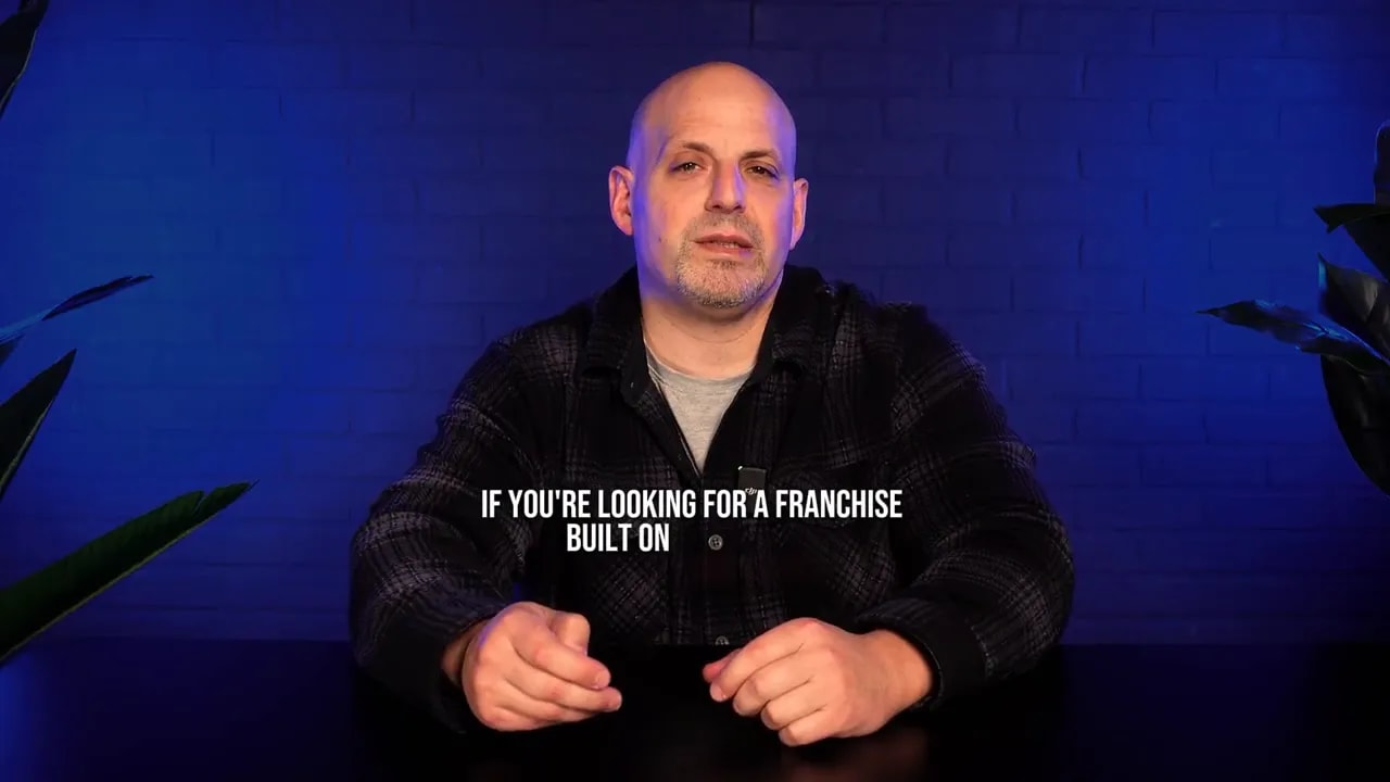 Presenter addressing the camera with on-screen summary text about choosing a franchise, blue studio background