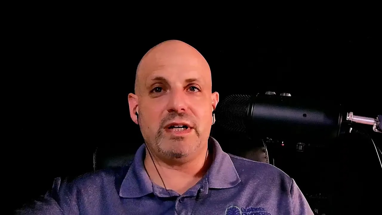 Man speaking into a microphone against a dark background