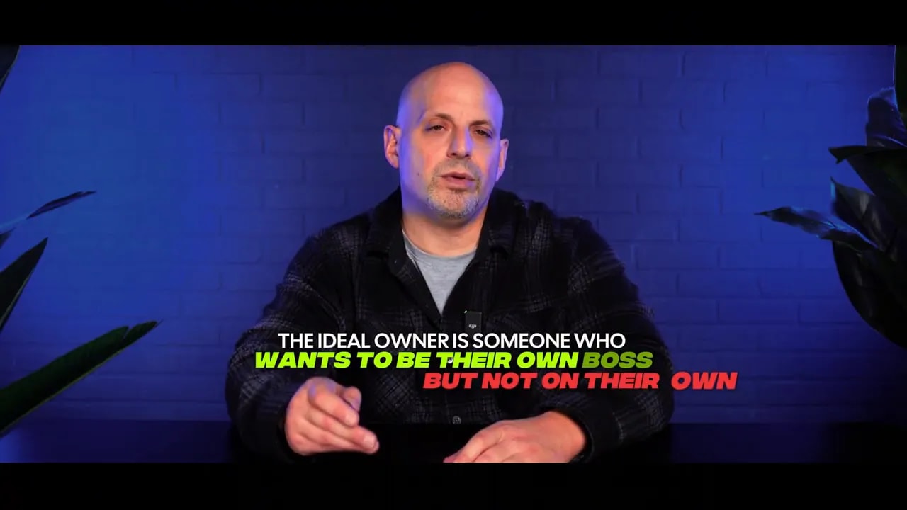 Presenter at desk with on-screen caption 'Wants to be their own boss' over blue brick background