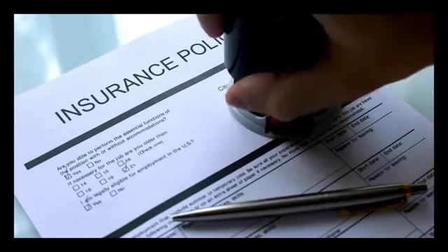Insurance policy document with approved stamp and pen