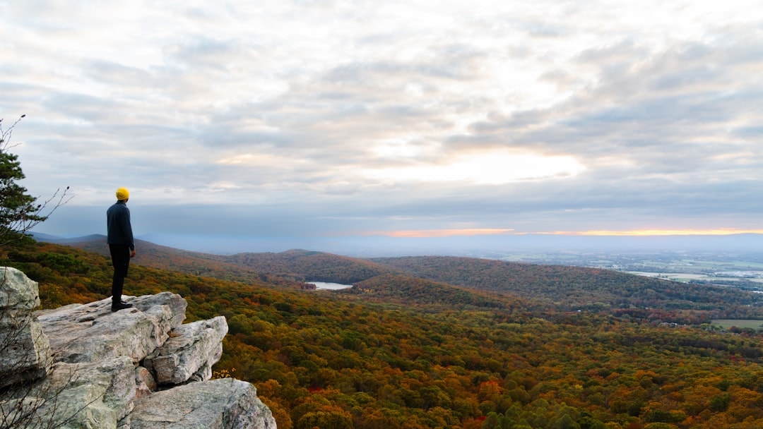 person standing on cliff sunrise