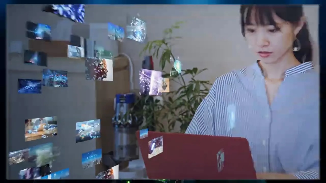 Person working at a desk on a laptop with multiple screens and office environment