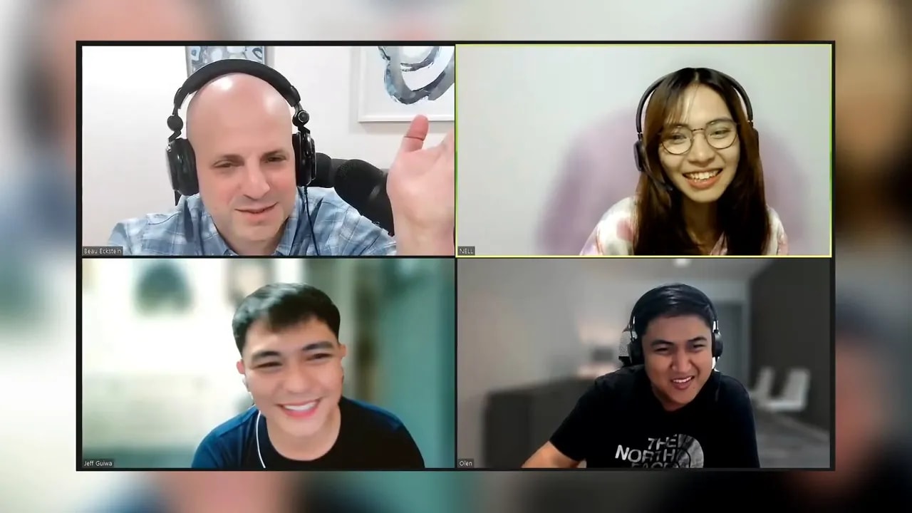 Screenshot of a four-person video meeting with smiling participants on a grid.