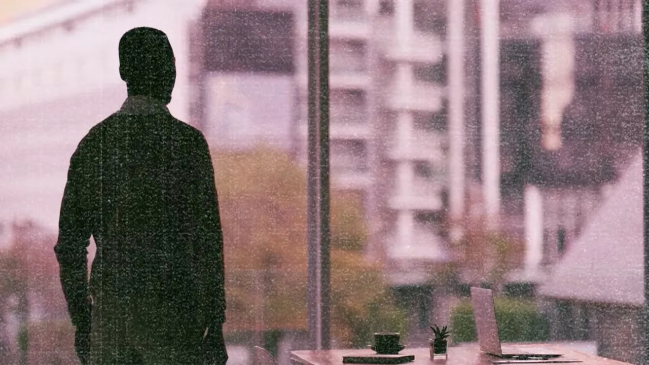 Silhouette of a person looking toward a city view through windows, representing taking action on the path to confidence
