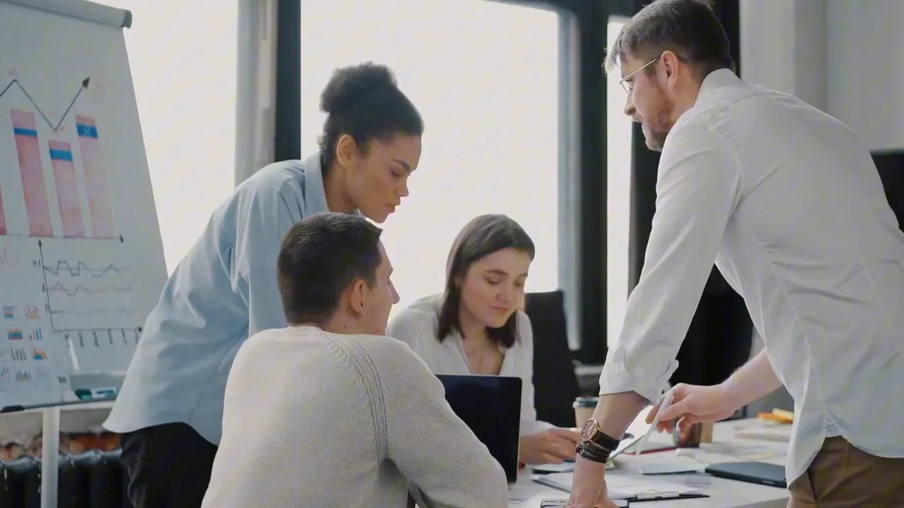 Four professionals collaborating around a table with a planning board