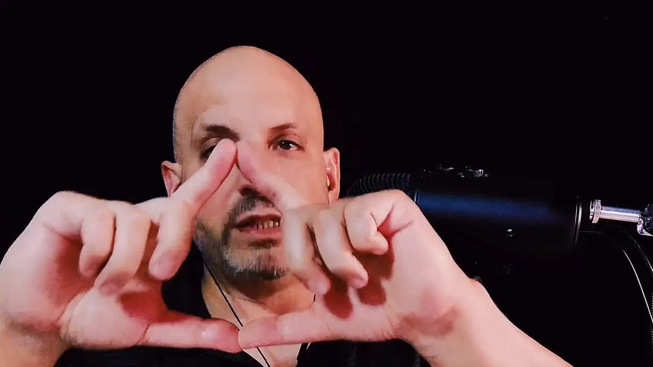 Hands forming a triangle shape in front of a microphone