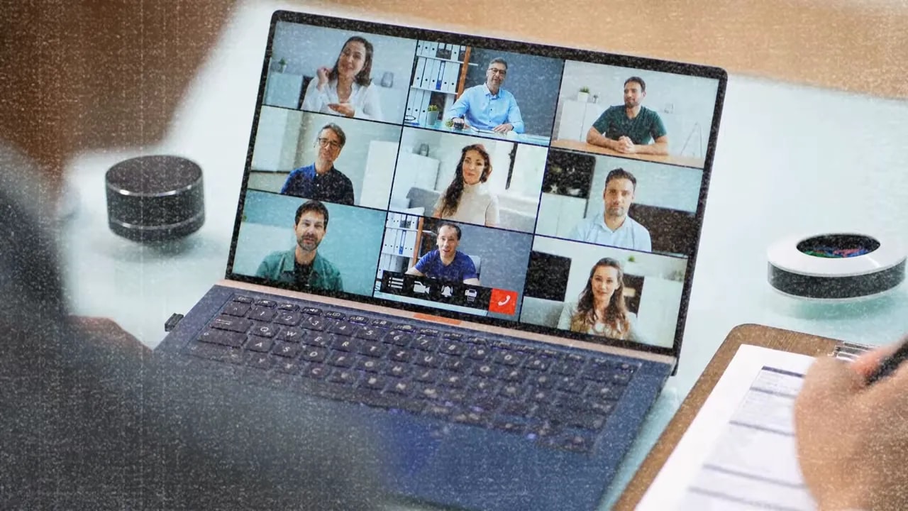 Video call grid on a laptop showing multiple participants