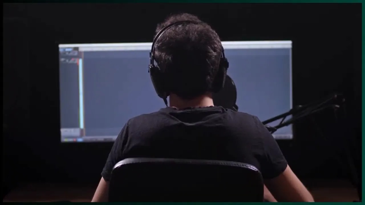 Person wearing headphones working at a computer monitor
