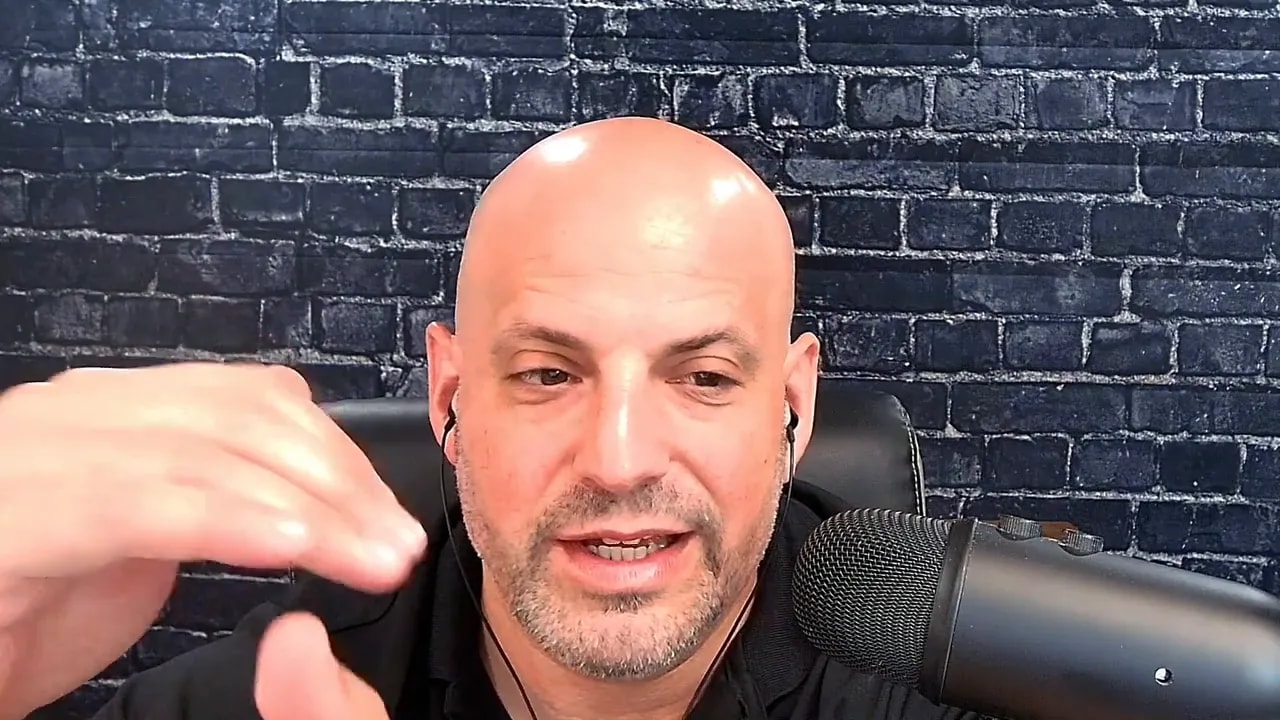 Business coach speaking and gesturing with one hand near a microphone while discussing repurposing actions